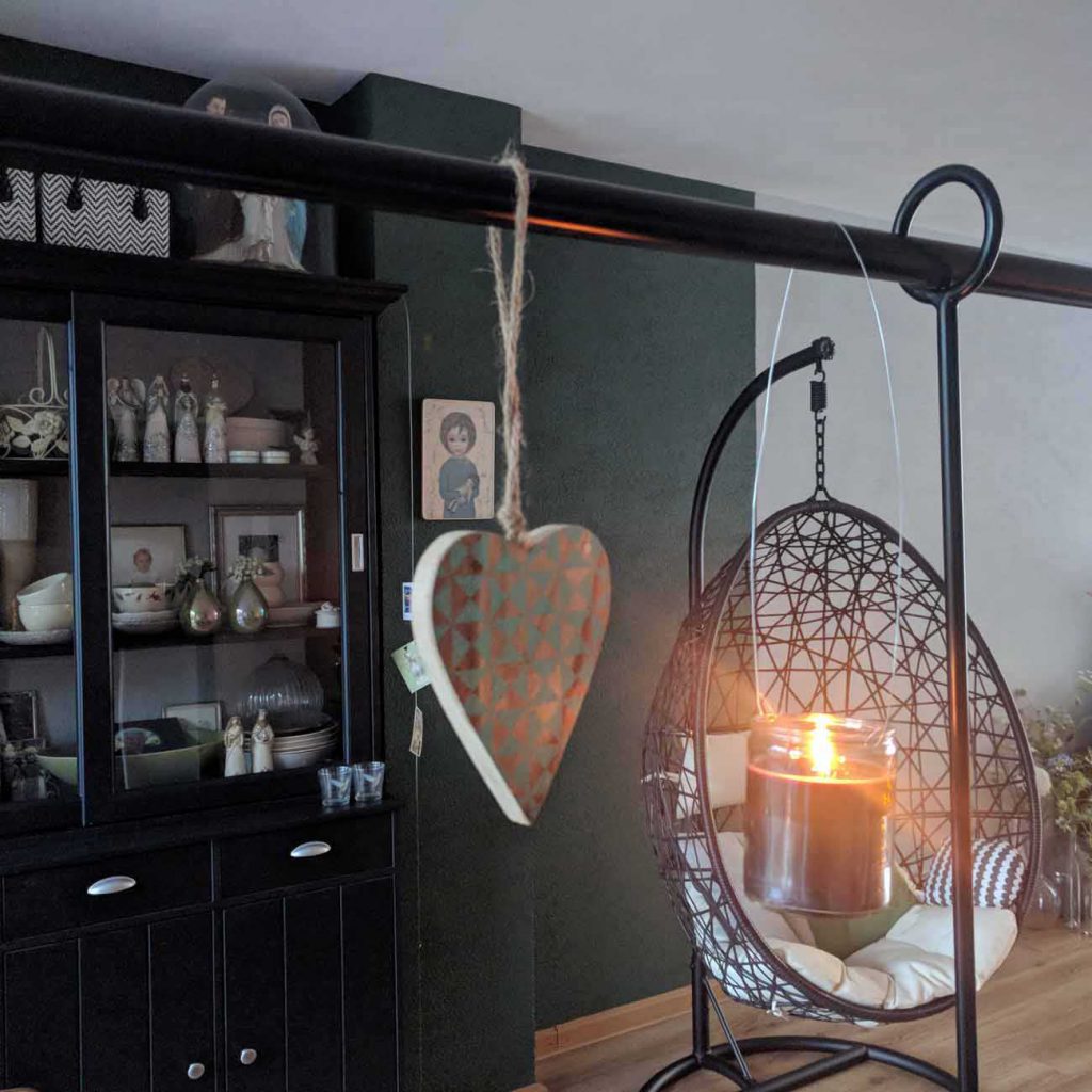 wwonkamer met een groene muur en zwarte kasten en een ei stoel